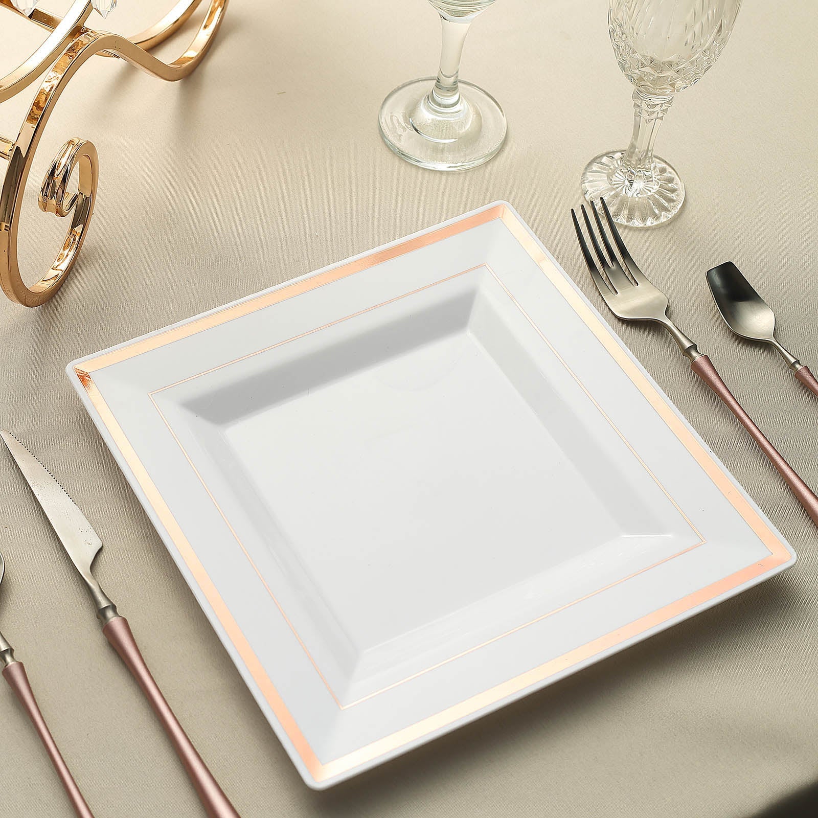 Rose gold trim white square disposable dinner plate on a table setting.