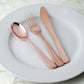 Rose gold disposable cutlery set on a white plate.