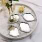 Silver oval baroque mini party favor candy trays on a marble surface.