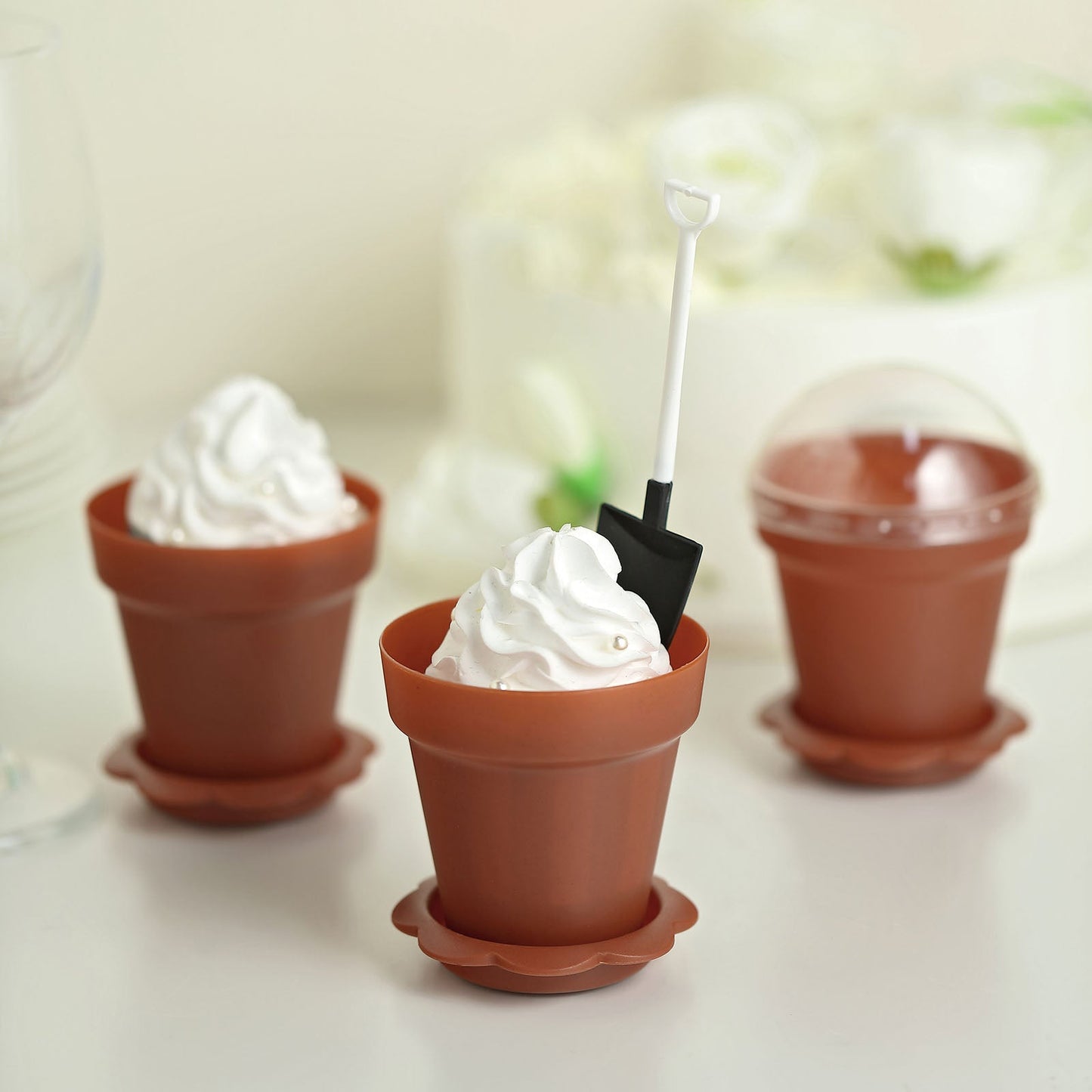 Rust terracotta succulent planter pots with clear lids and trays.