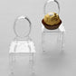Clear chair shaped party favor holders with candy treats displayed.