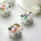 Silver party favor gift boxes filled with pastel candy treats.