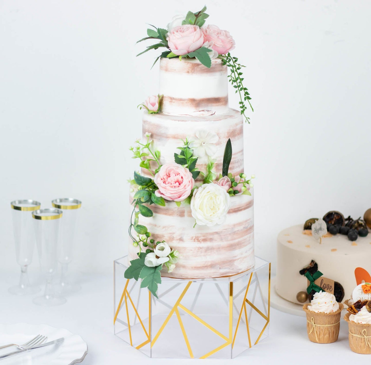 Clear and gold acrylic hexagonal cake box stand with hollow bottom.