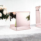 Rose gold mirrored acrylic pedestal risers for display.