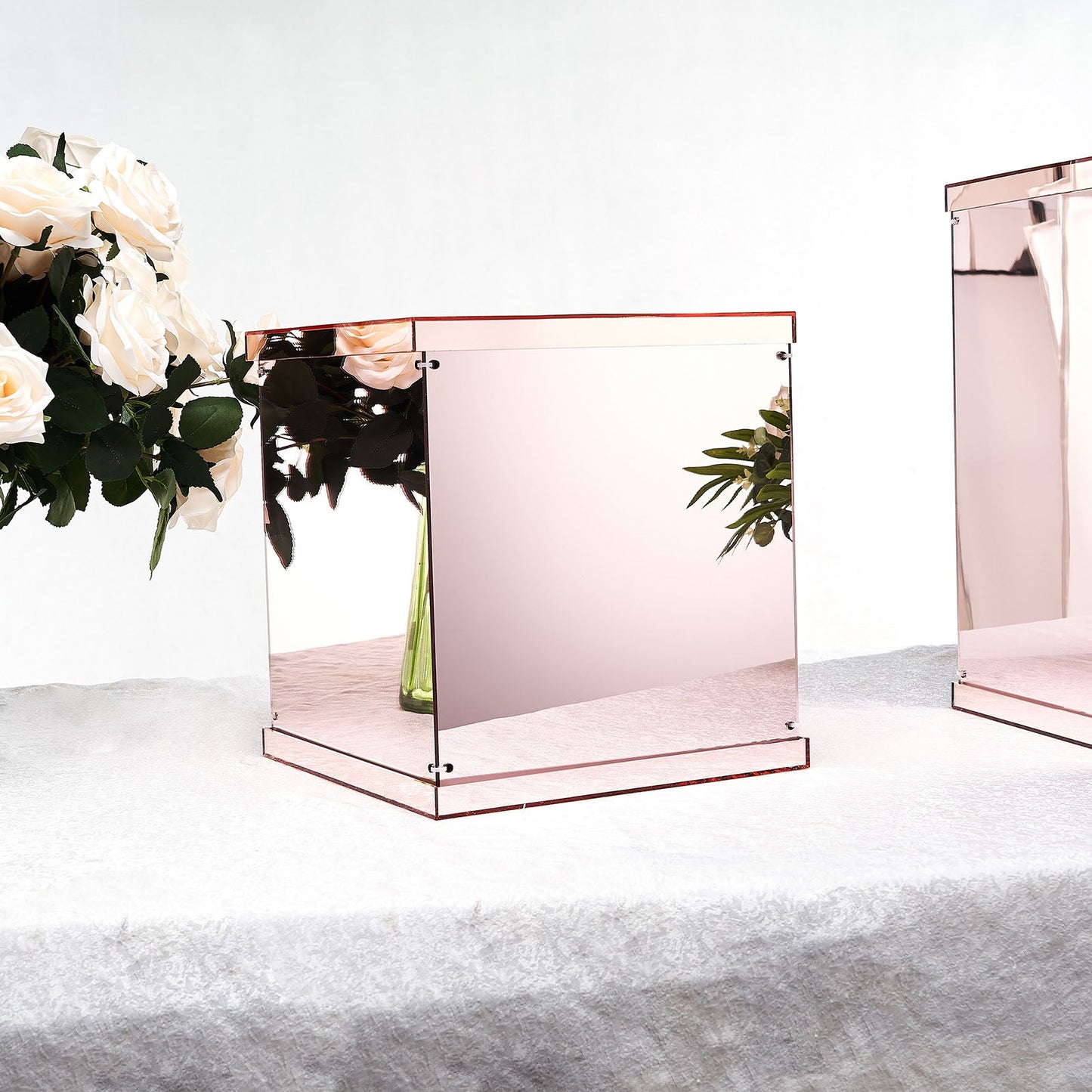 Rose gold mirrored acrylic pedestal risers for display.