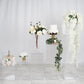Clear acrylic pedestal risers for display with floral arrangements and decor.