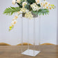 Clear acrylic wedding centerpiece vase with flowers and square mirror base.