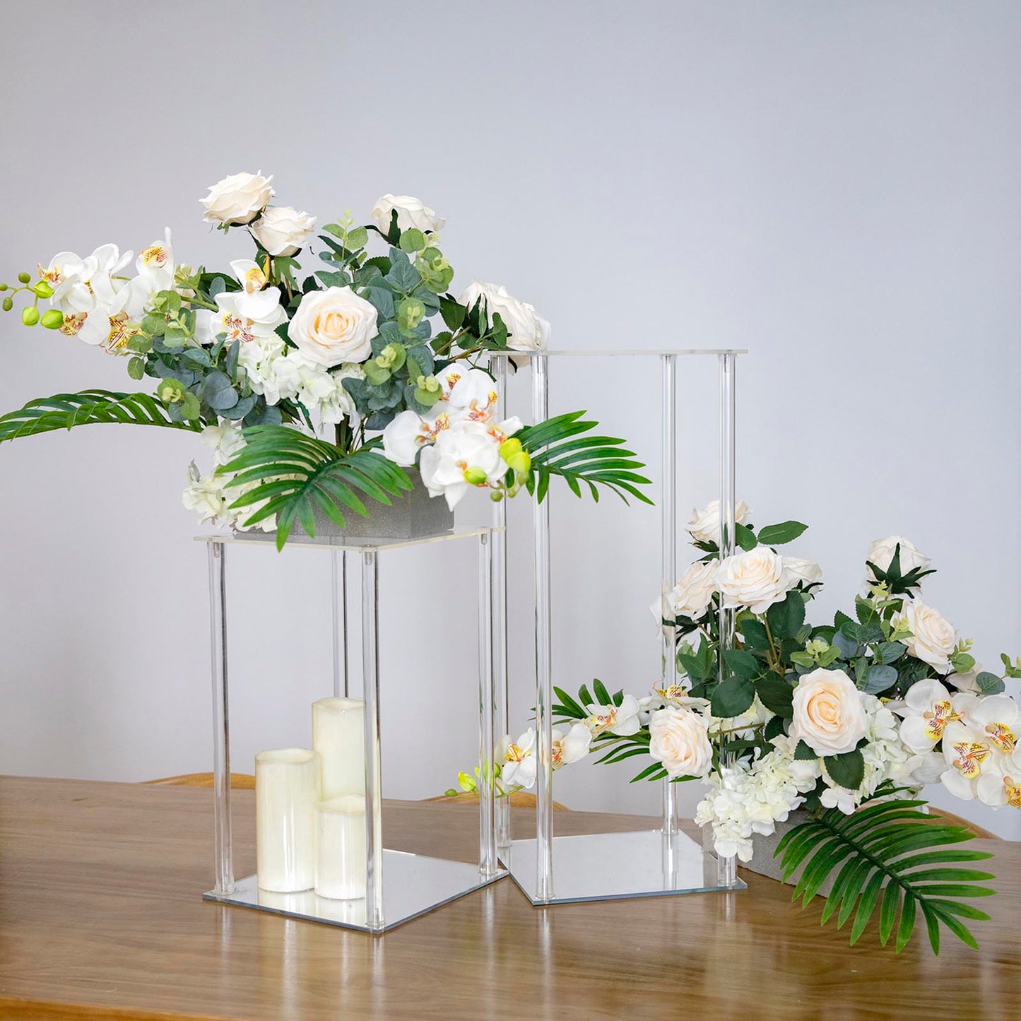 Clear acrylic wedding centerpiece vase with square mirror base, floral arrangement.