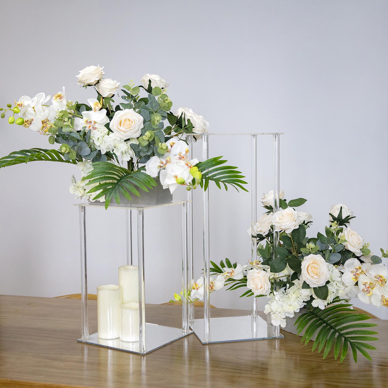 Clear acrylic wedding centerpiece vase with square mirror base, floral arrangement.