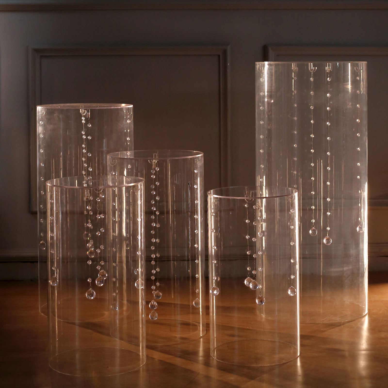 Clear acrylic cylinder pedestal stands for wedding display.