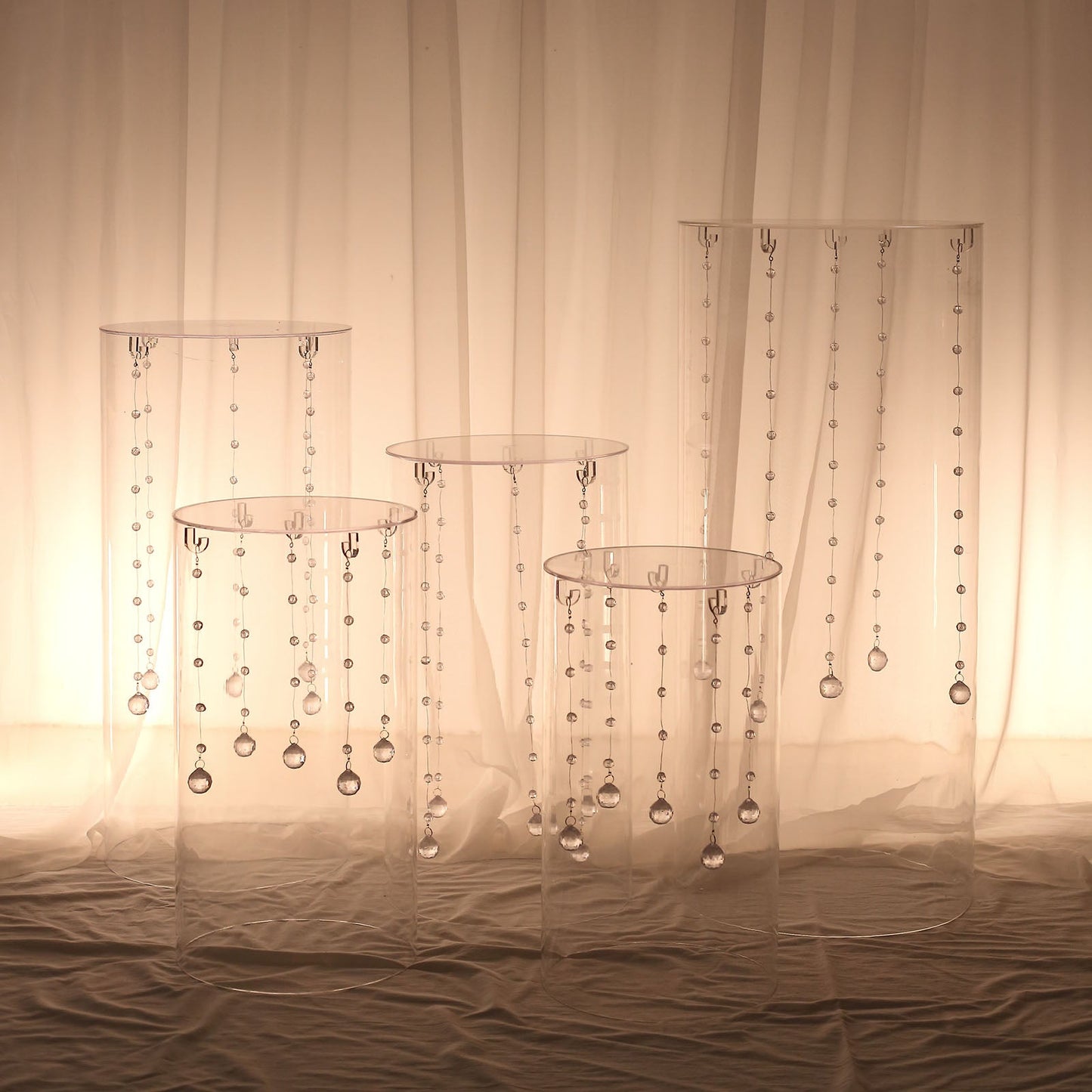 Clear acrylic pedestal stands with hanging hooks for cake display.
