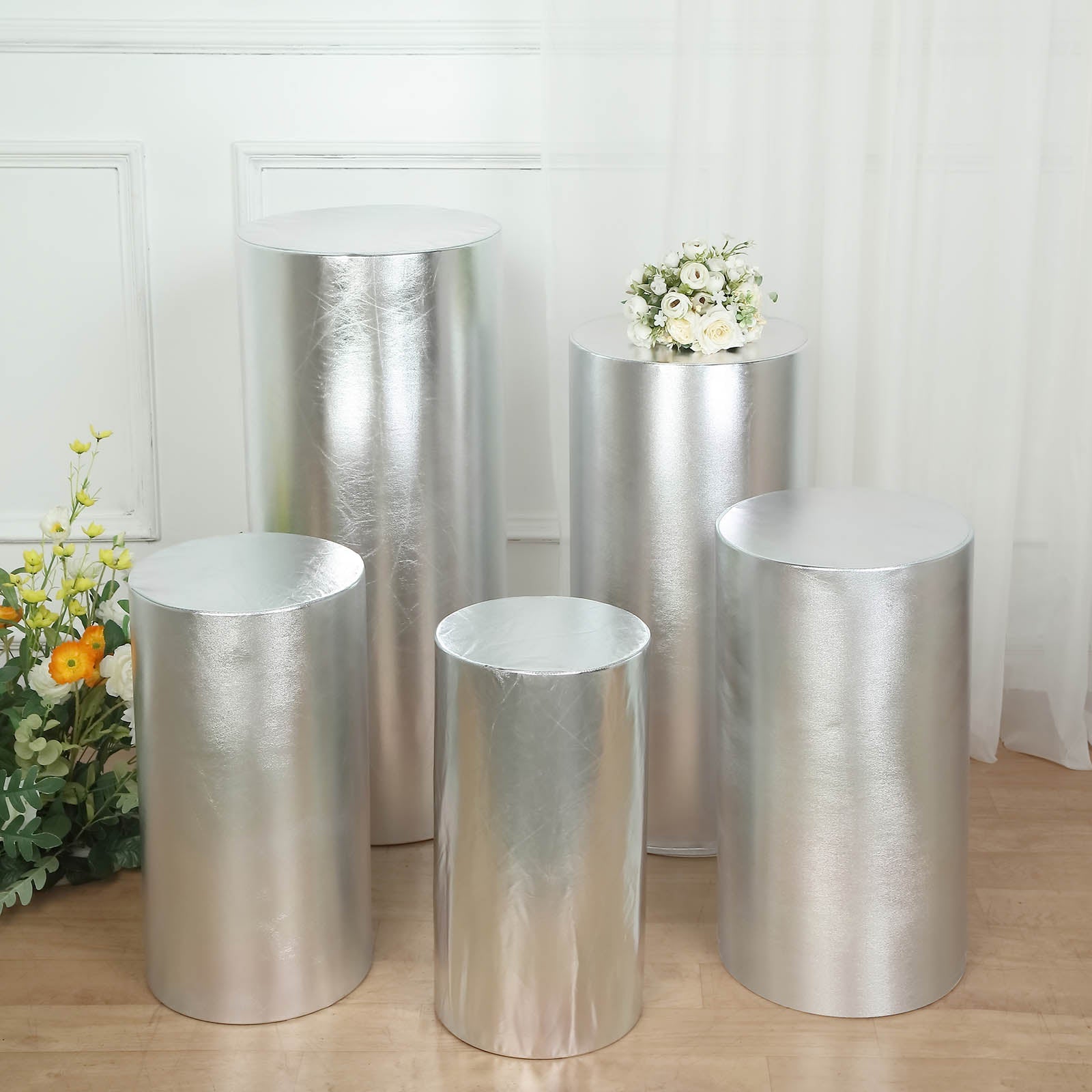 Set of 5 shiny silver spandex pedestal stand covers for events.