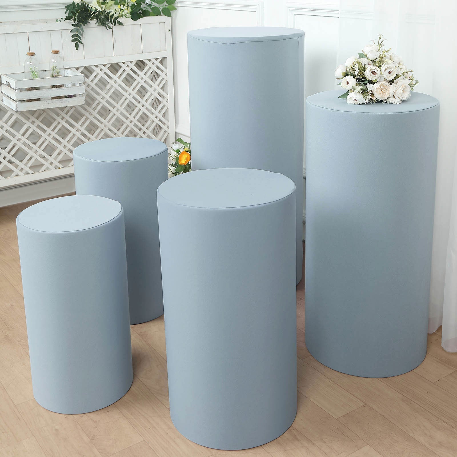 Dusty blue spandex pedestal stand covers for events and displays.