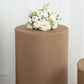 Taupe spandex pedestal stand cover with floral arrangement on top.