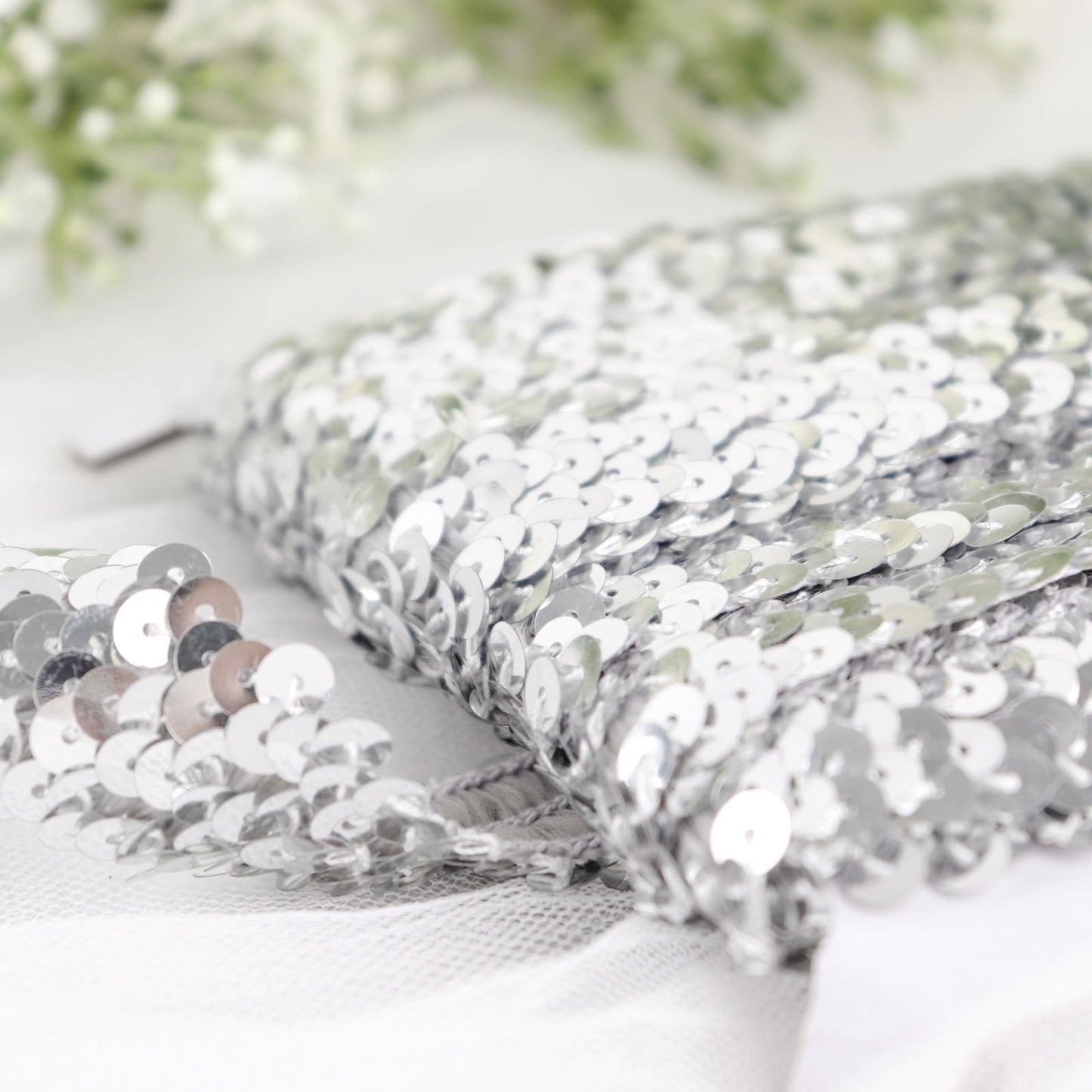 Metallic silver sequin stretch fabric ribbon with shiny glitter.