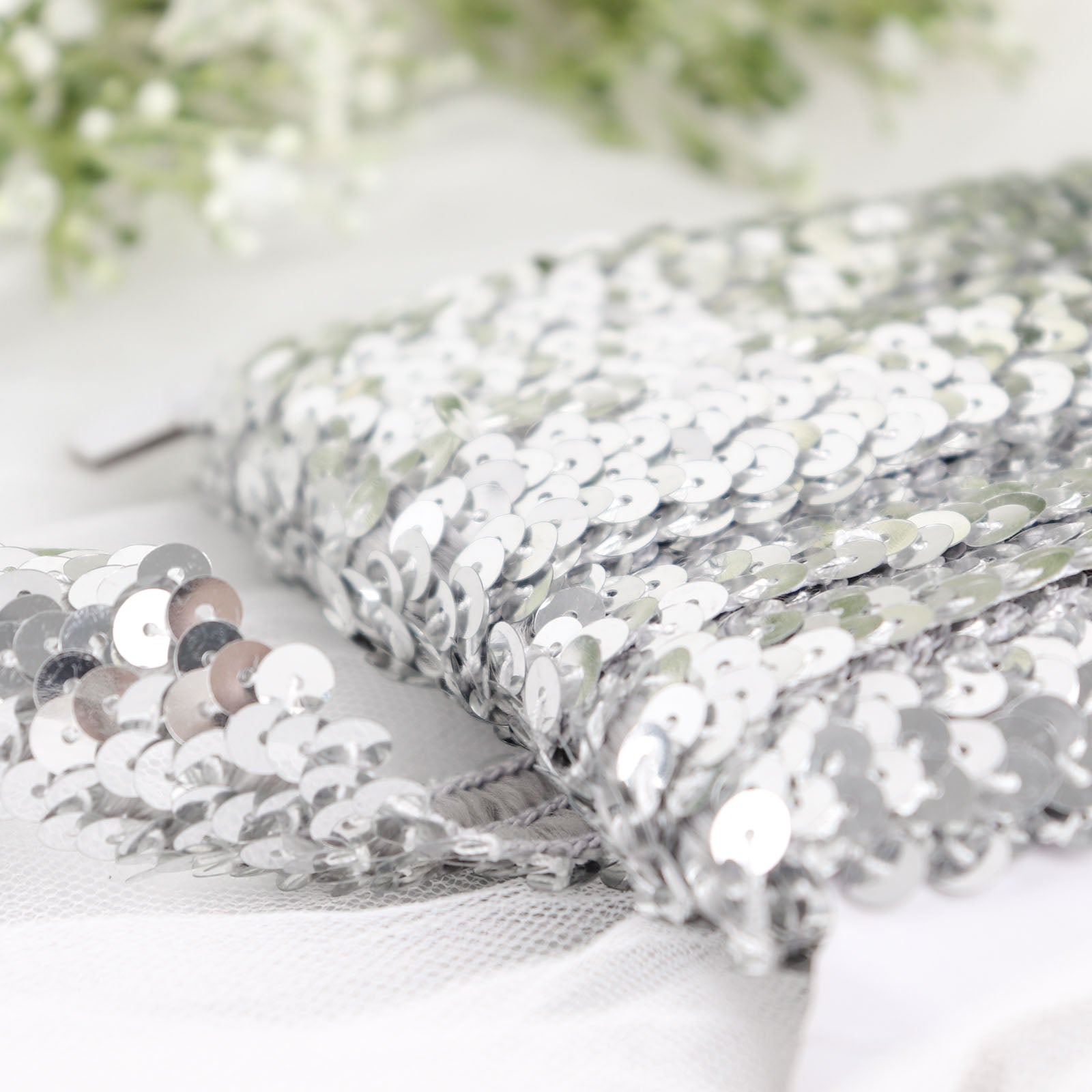Metallic silver sequin stretch fabric ribbon with shiny glitter.