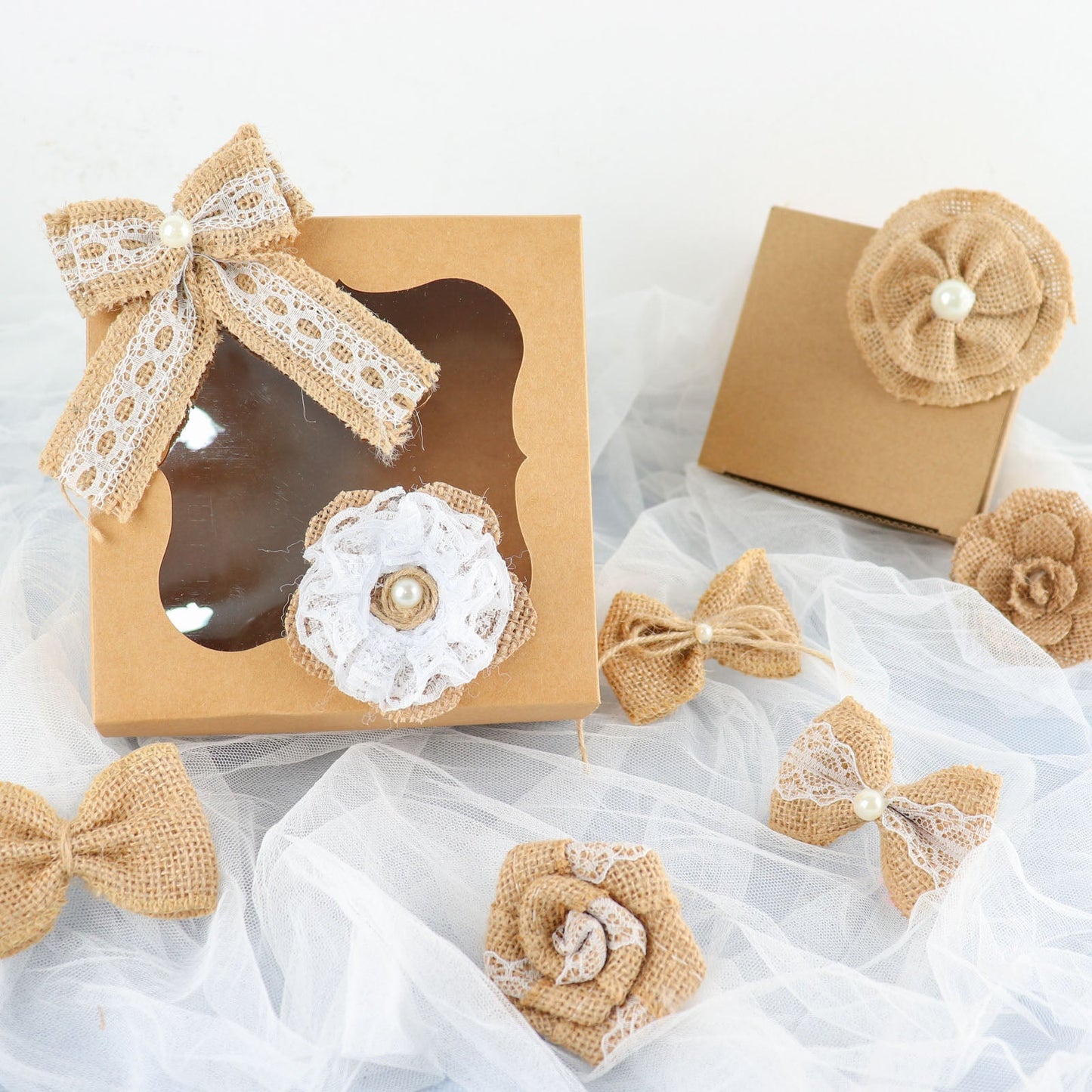Natural burlap flower and bows set with lace ribbon on a light background.