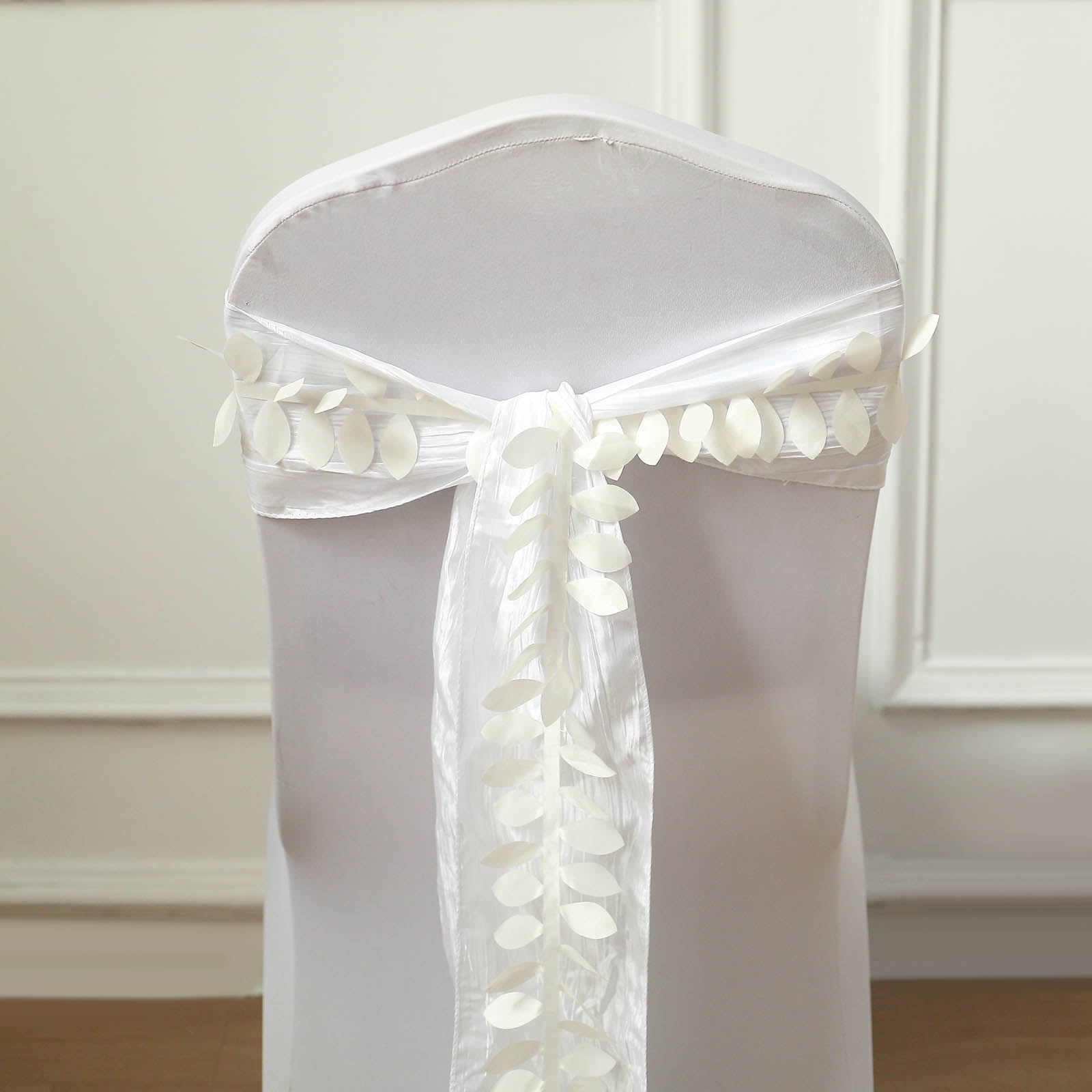 Ivory leaf petal taffeta ribbon sash on a white chair.
