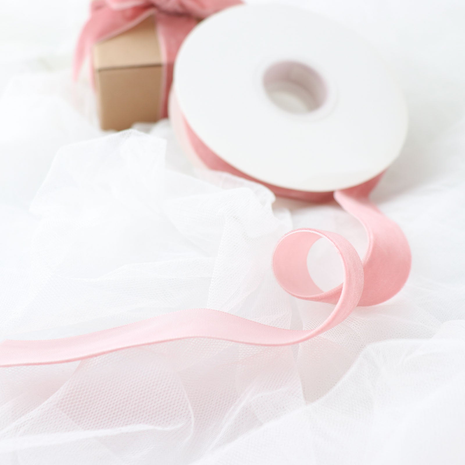 Dusty rose velvet ribbon spool for DIY crafts.