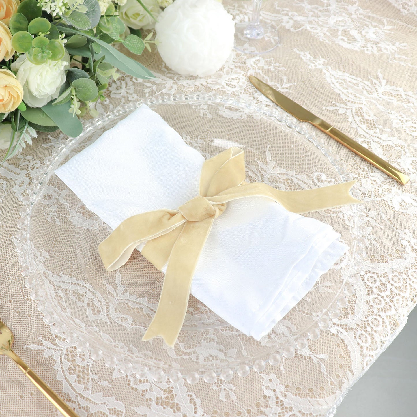 Champagne velvet ribbon spool for DIY crafts on a decorative table setting.