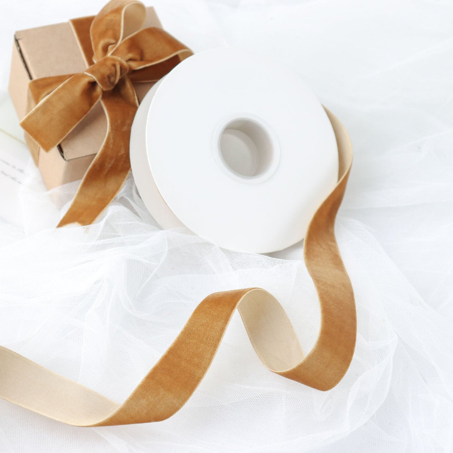 gold velvet ribbon spool on a white background with a gift box
