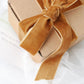 Gold velvet ribbon tied around a gift box.