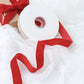 Red velvet ribbon spool for DIY crafts.