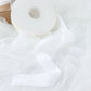 White velvet ribbon spool on a white fabric background.