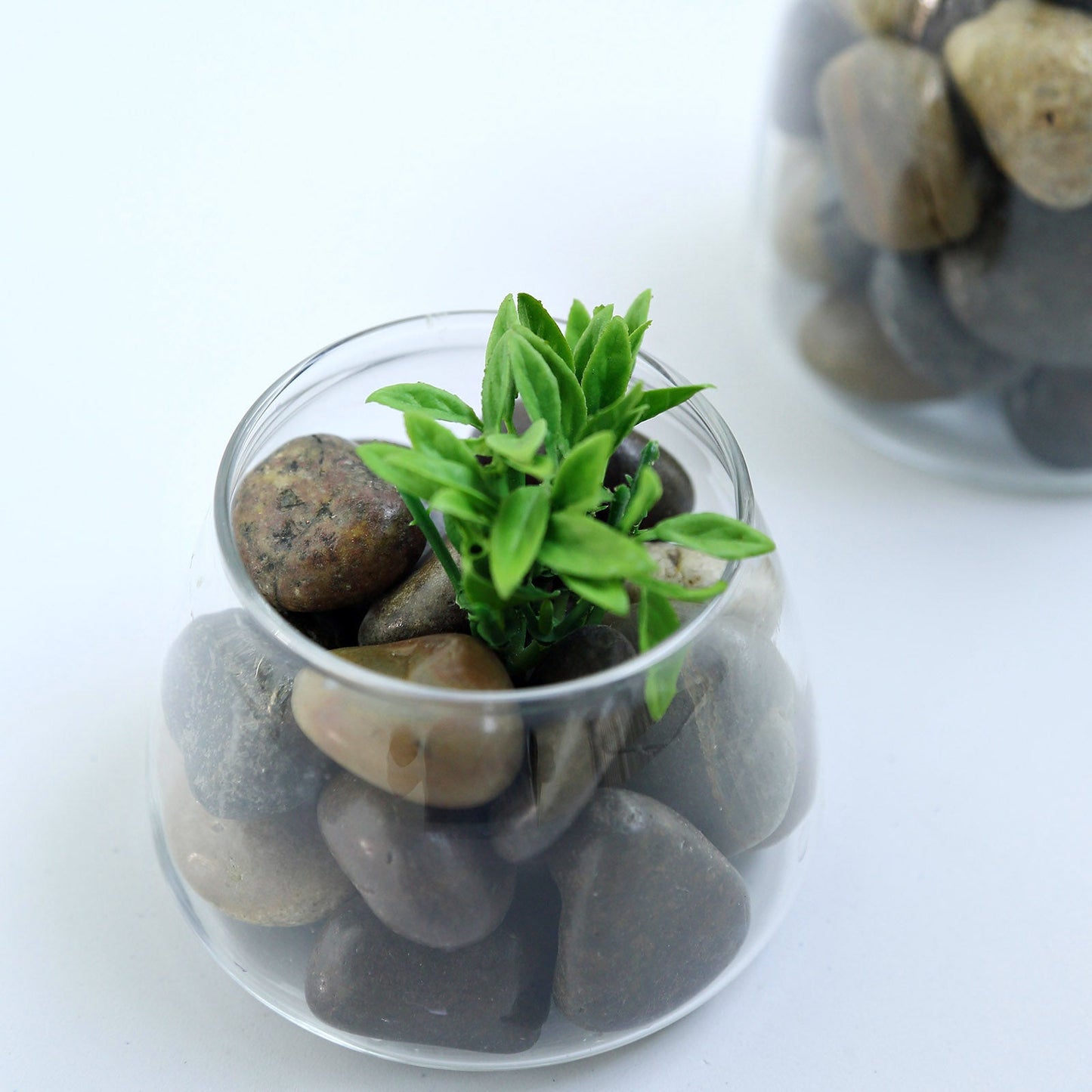 Assorted natural polished decorative stones in a glass vase.