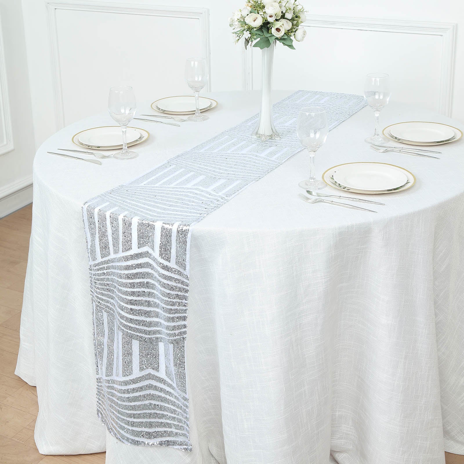 Silver diamond glitz sequin table runner on a white tablecloth.