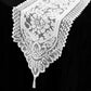 White lace table runner with intricate floral patterns.