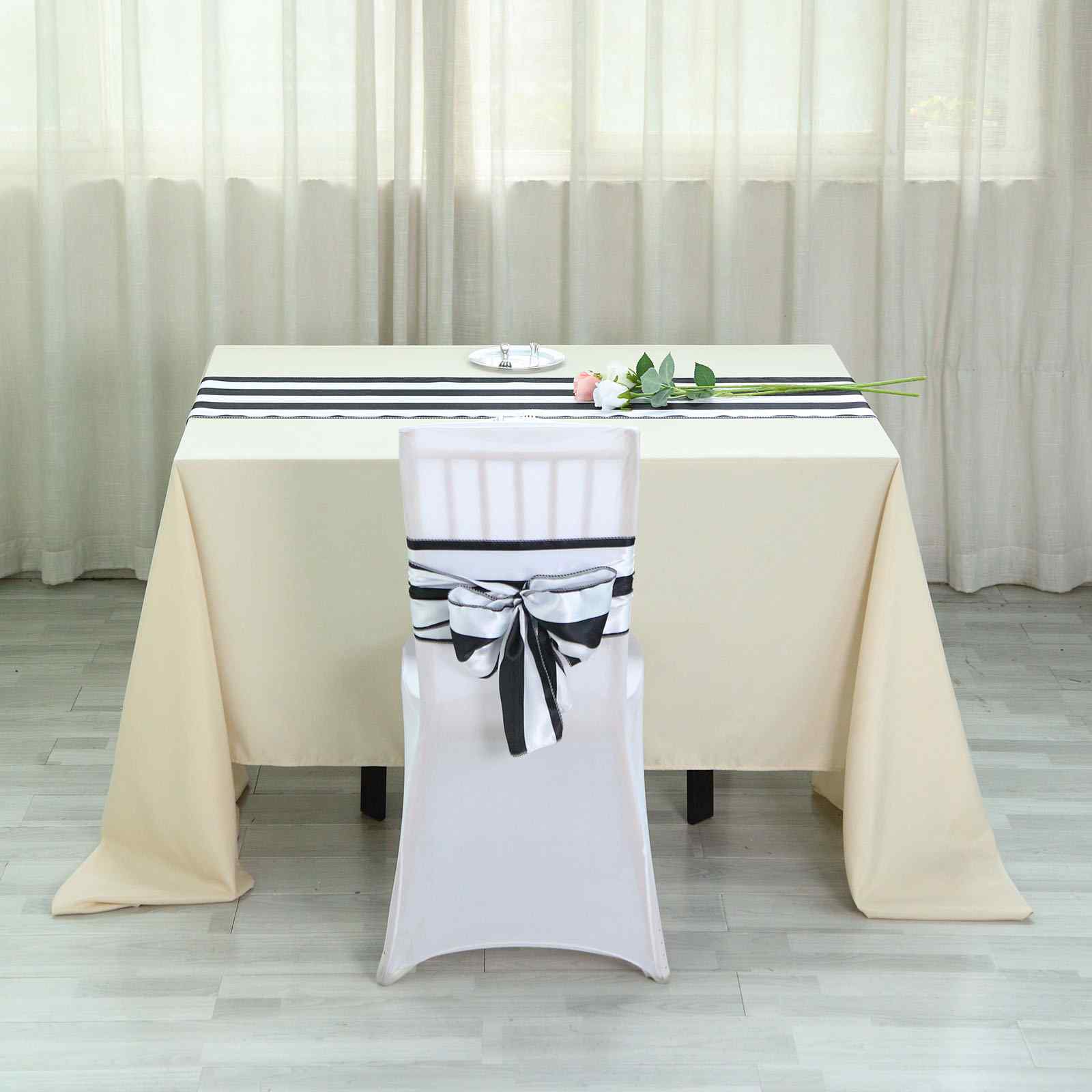 Black and white stripe satin table runner on a table setting.
