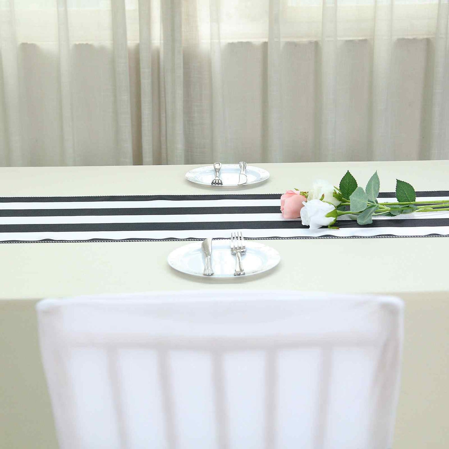 Black and white stripe satin table runner on a dining table.