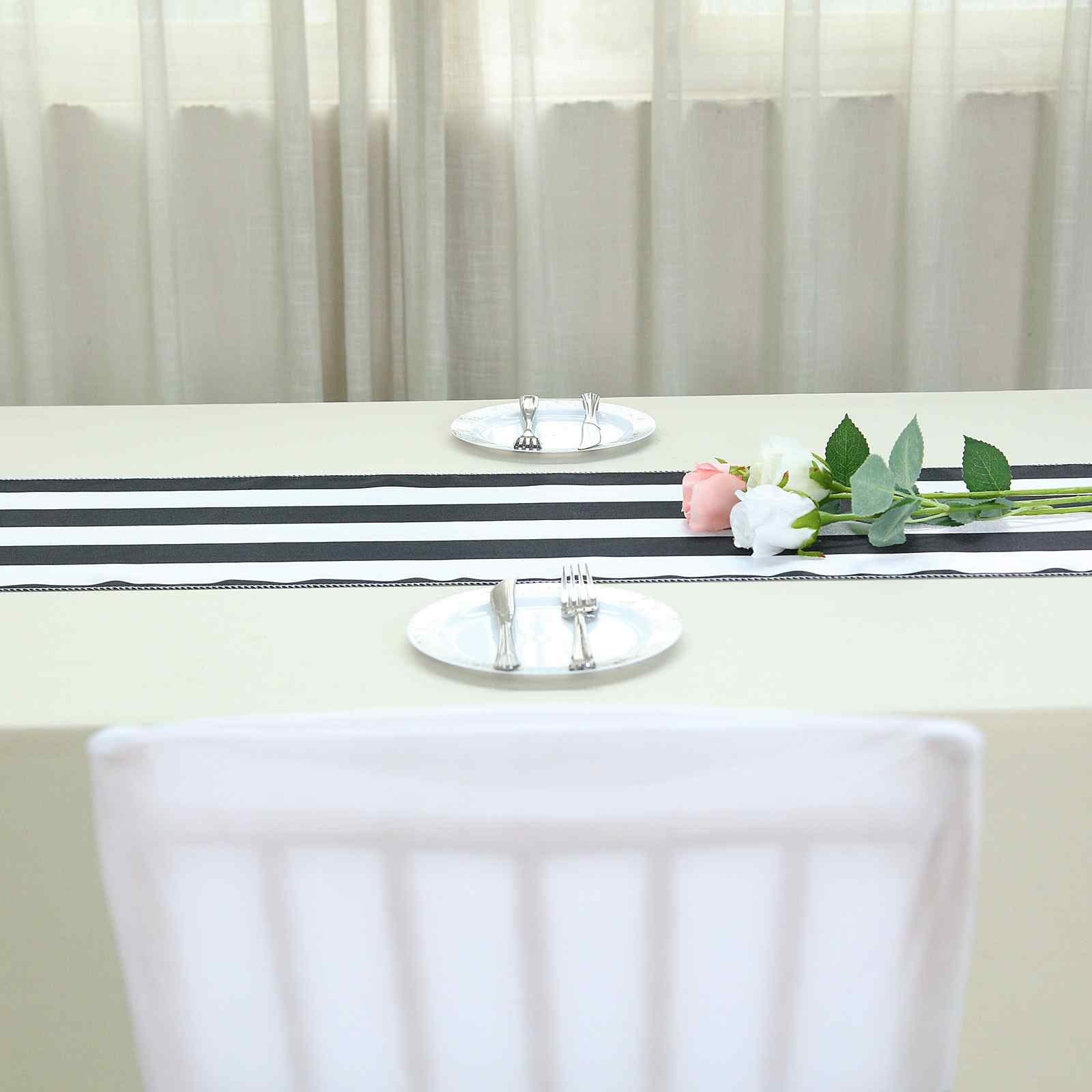 Black and white stripe satin table runner on a dining table.