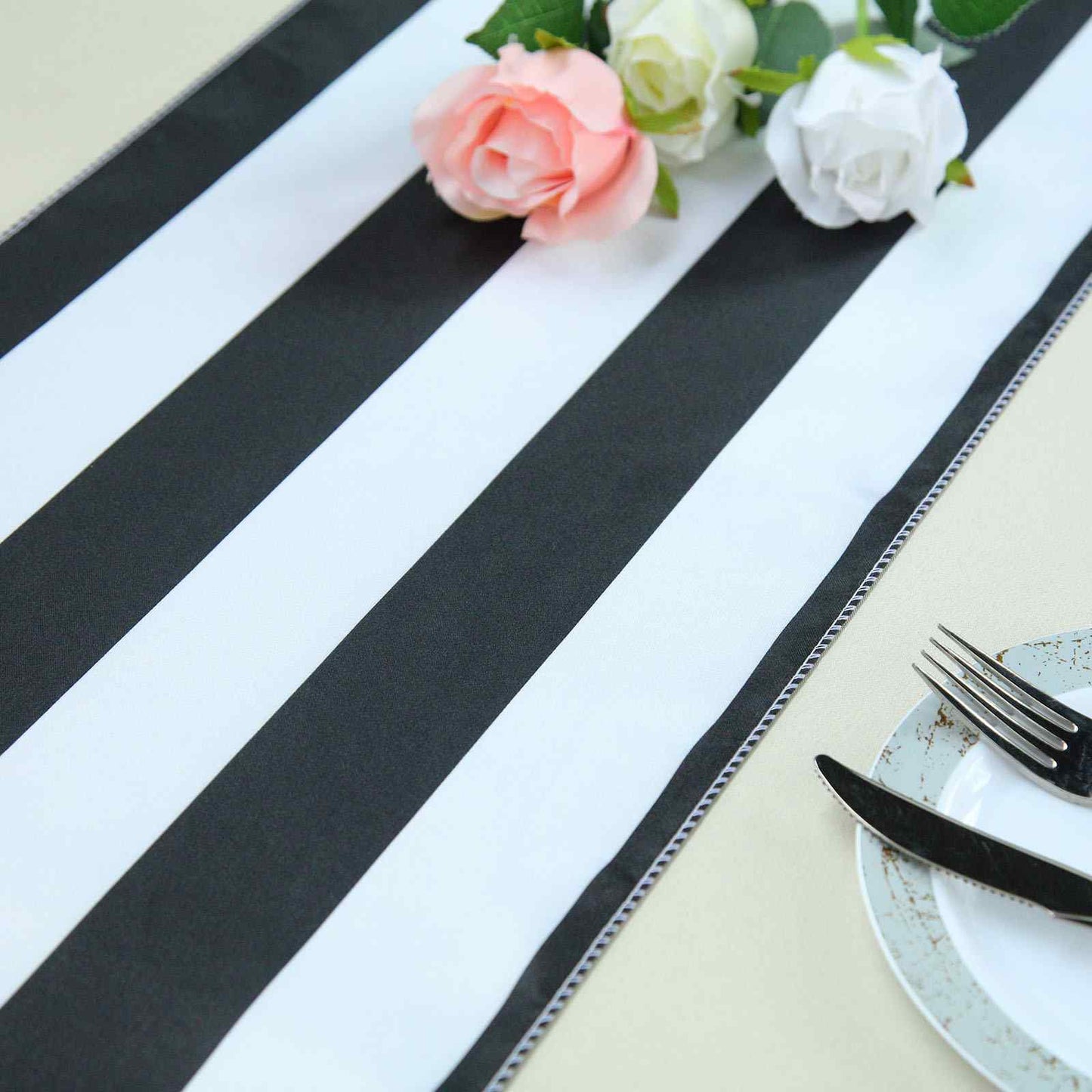 Black and white stripe satin table runner with floral decor.