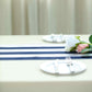 Navy and white stripe satin table runner on a dining table.