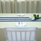 Navy and white stripe satin table runner on a beige table.