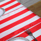 Red and white stripe satin table runner on a table setting.