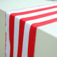 Red and white stripe satin table runner on a light-colored table.