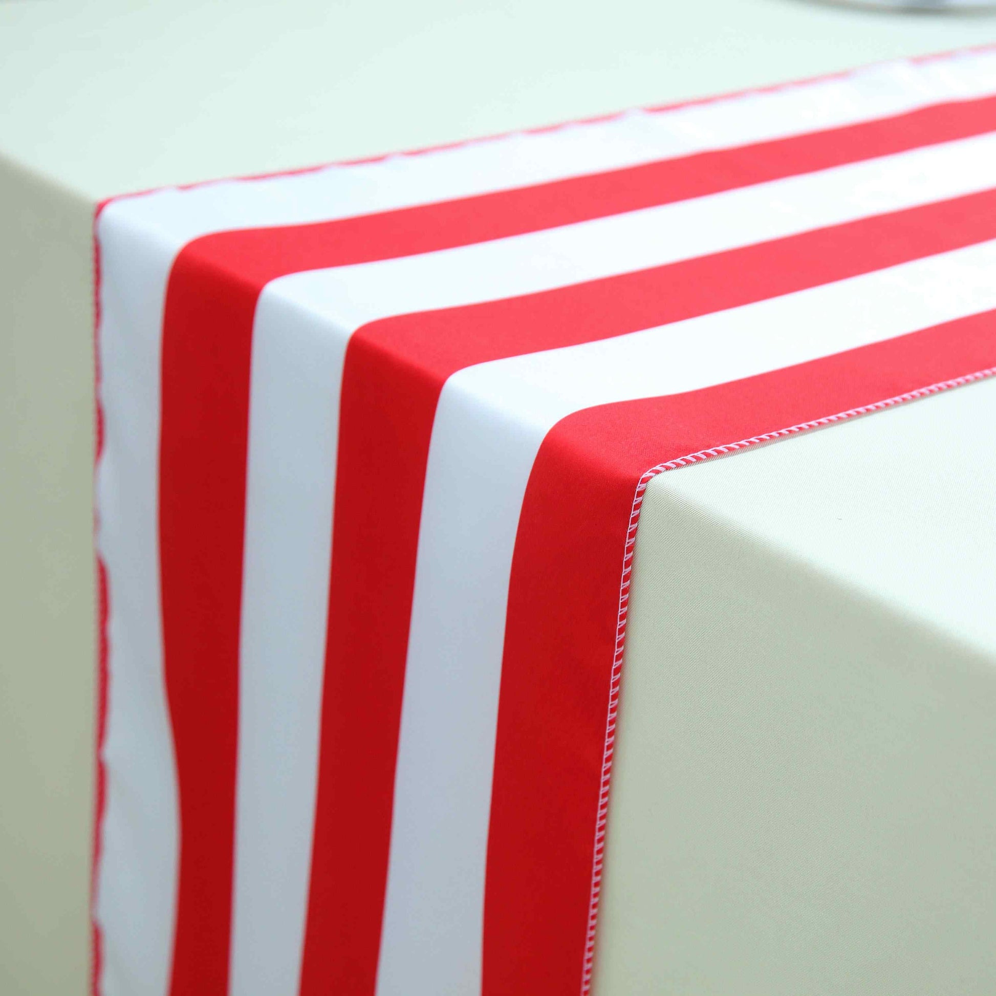 Red and white stripe satin table runner on a light-colored table.