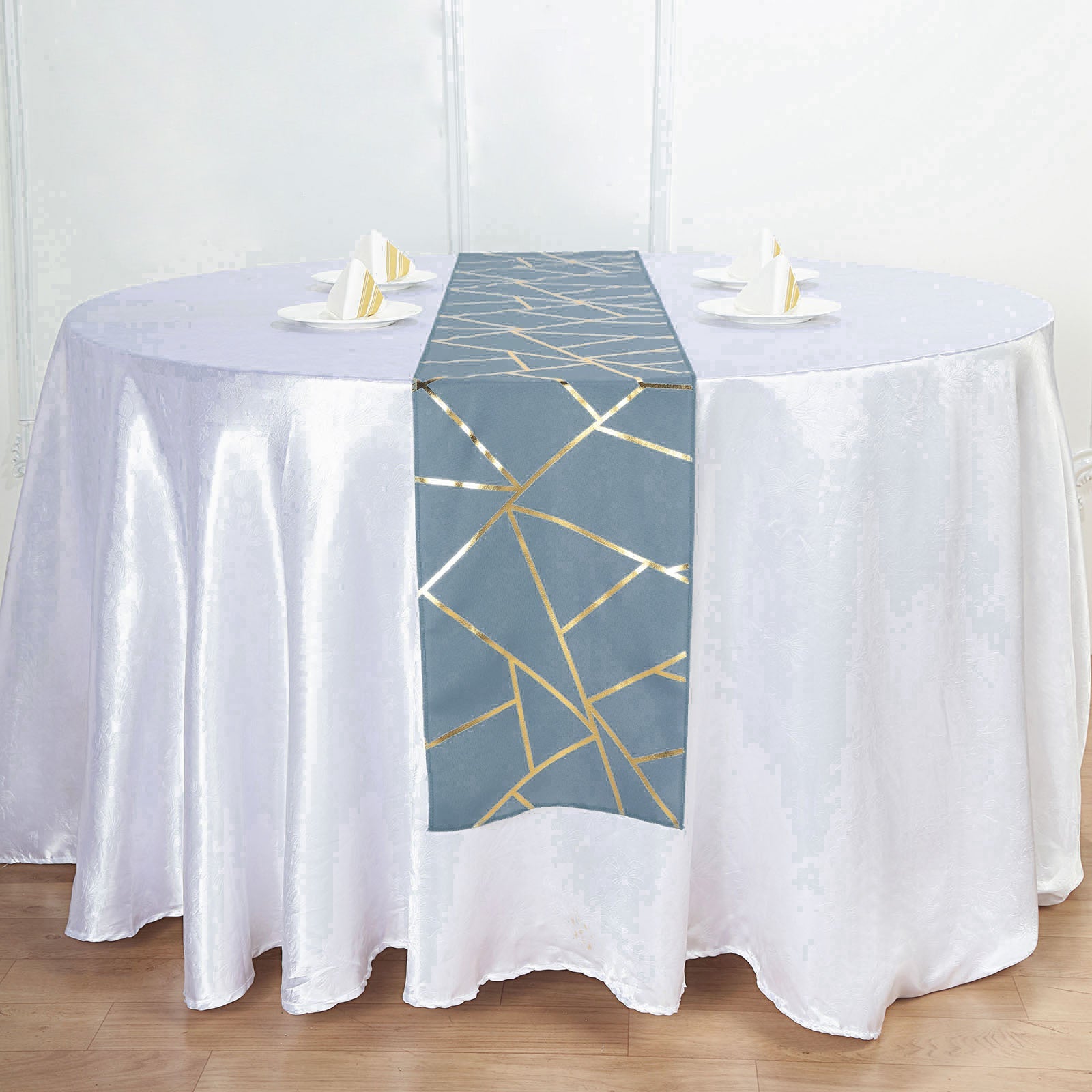 Dusty blue and gold foil geometric pattern table runner on a white table.