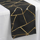 Black geometric pattern table runner with gold foil accents.
