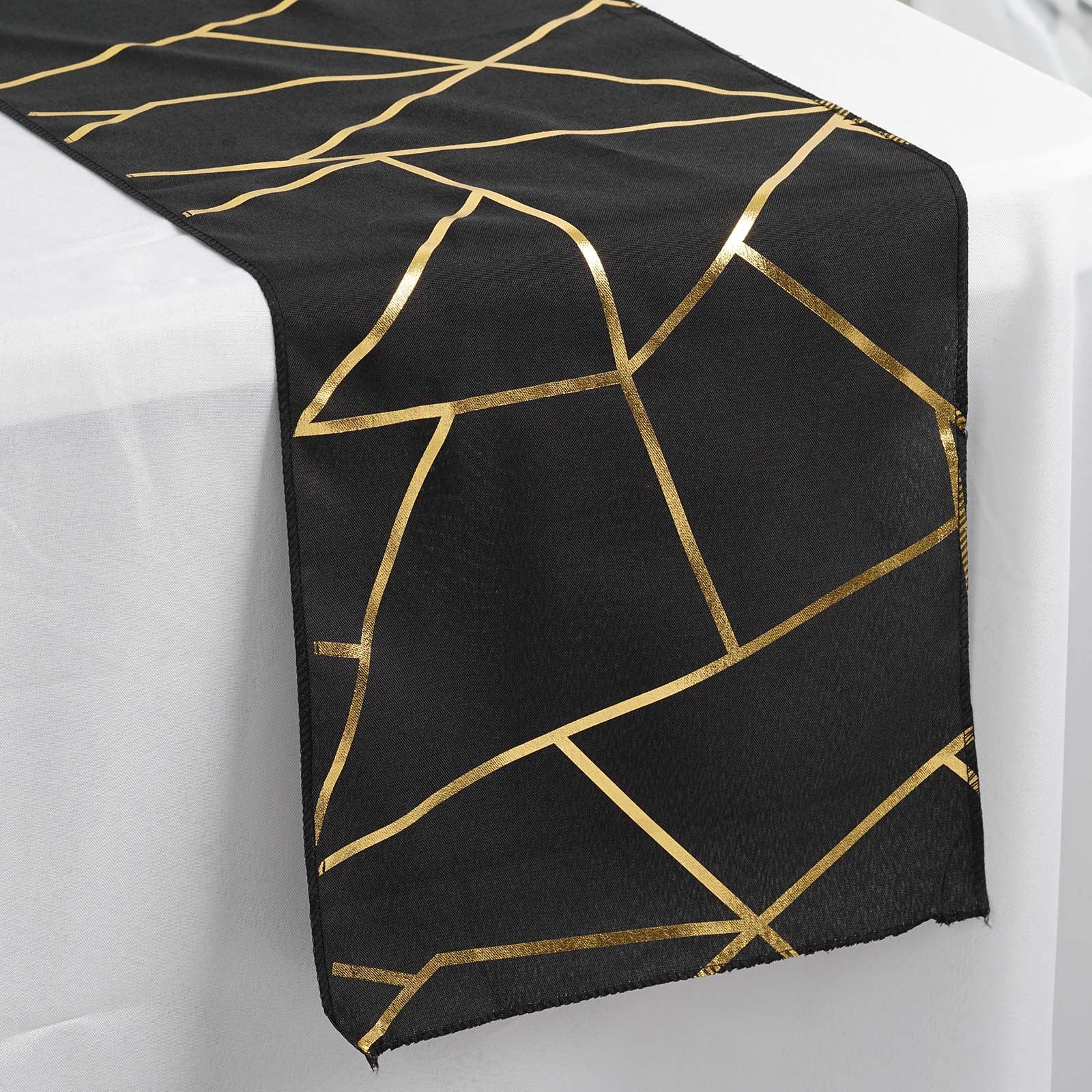 Black geometric pattern table runner with gold foil accents.