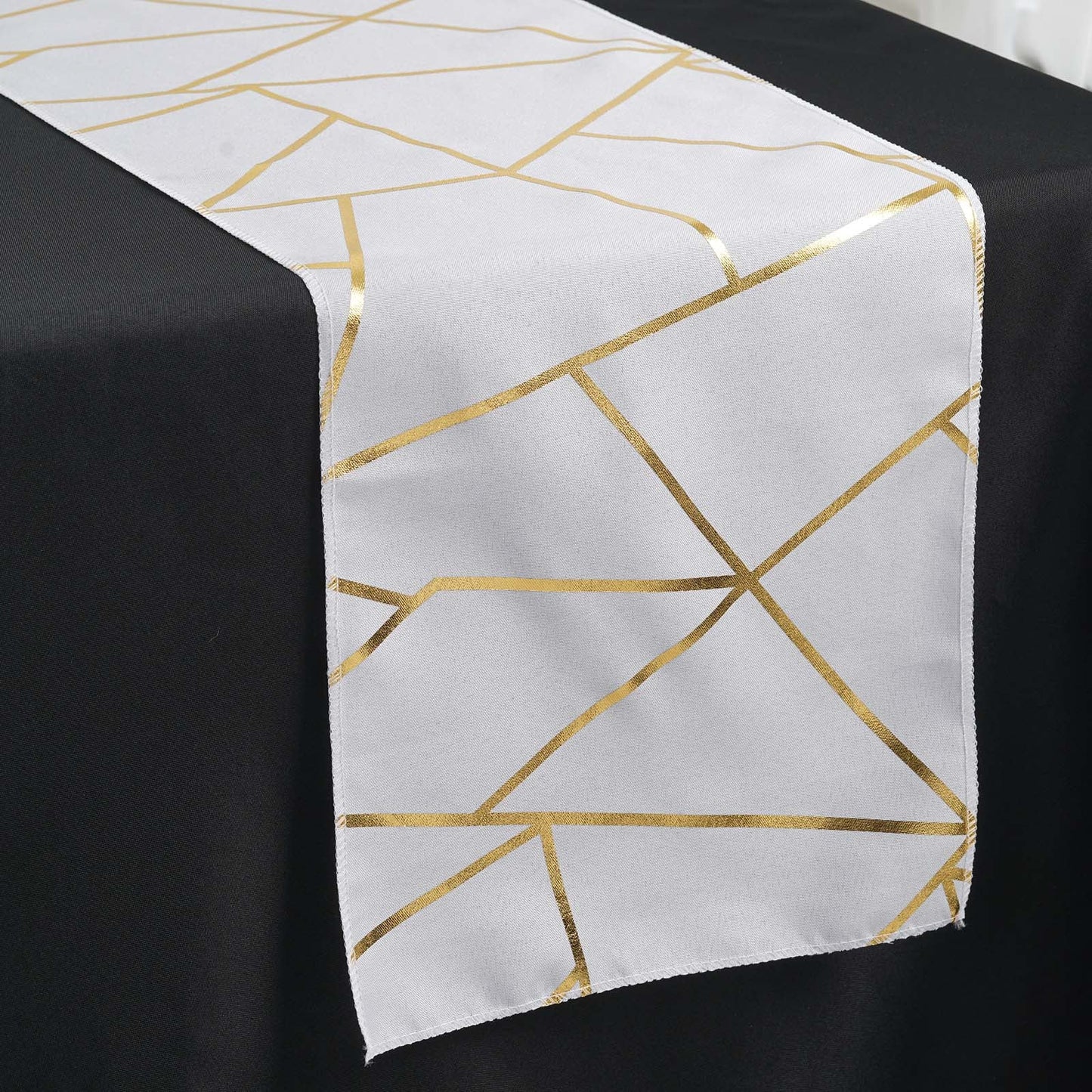 9ft white and gold geometric pattern table runner on a black table.