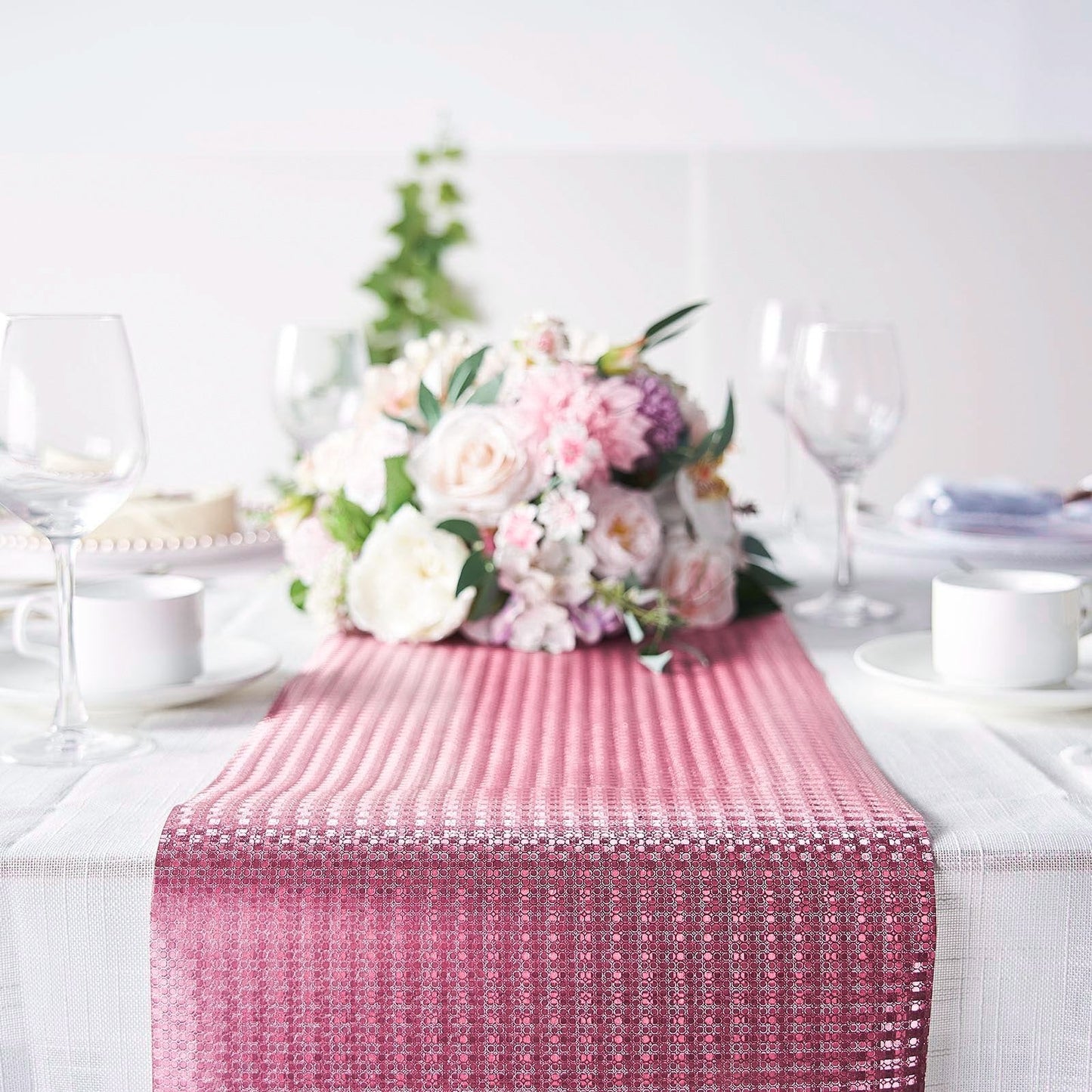 Rose gold sequin print table runner on a dining table with flowers.