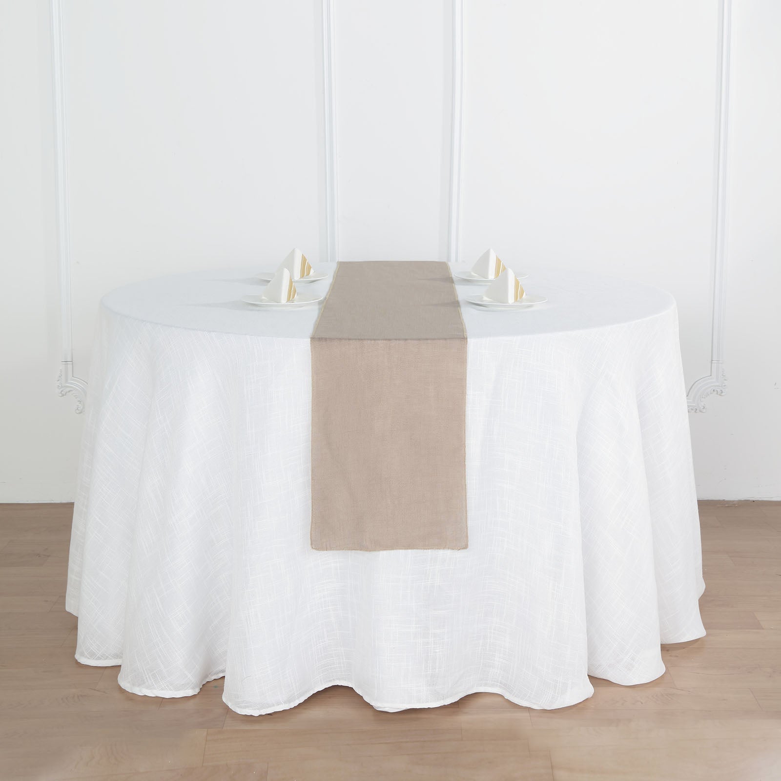 Taupe linen table runner on a round white table setting.