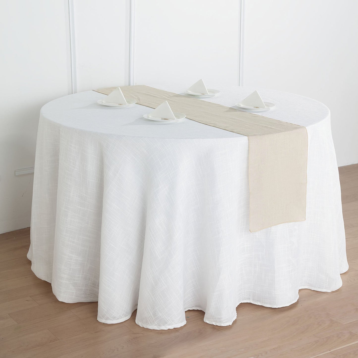 Beige linen table runner on a round table setting.