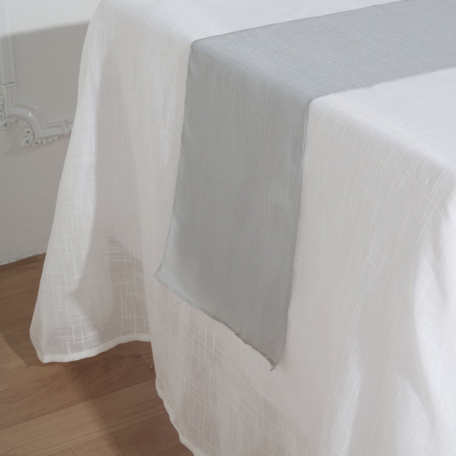Silver linen table runner on a white table.