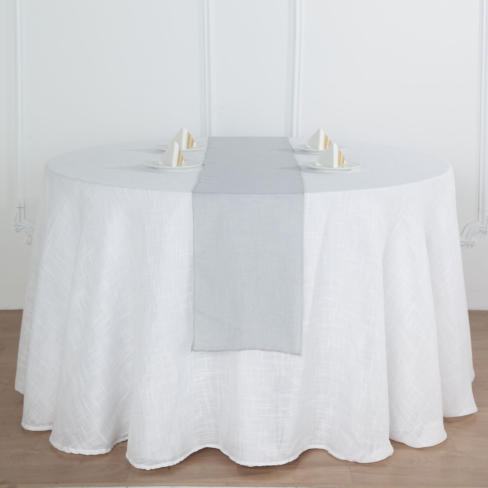 Silver linen table runner on a round table setting.