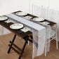 White faux burlap jute table runner with lace edging on a rustic table setting.